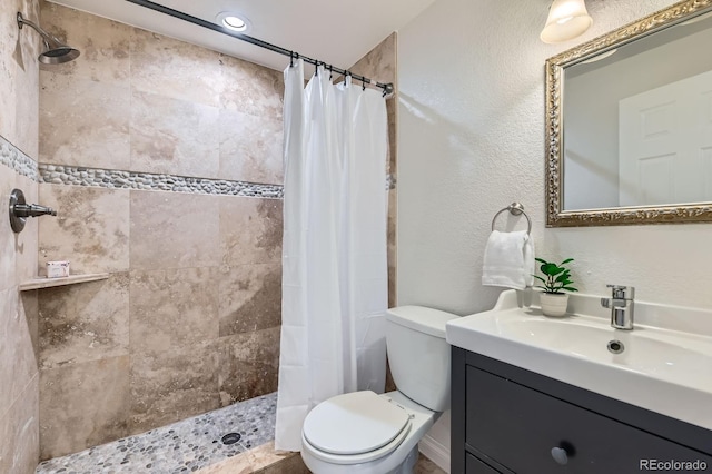 744 Owl Dr, Louisville, CO 80027 - full bath featuring toilet, vanity, a tile shower, and a textured wall