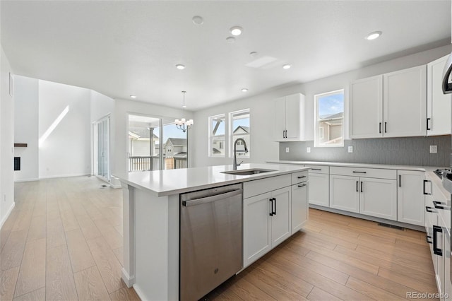 kitchen with dishwasher, a sink, a center island with sink, and light wood-style flooring