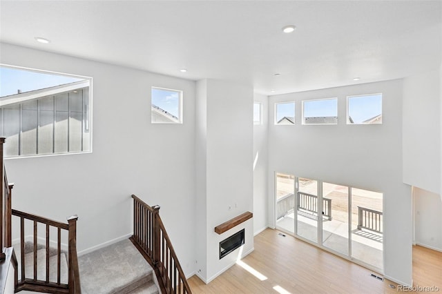 stairway featuring wood finished floors, visible vents, and recessed lighting