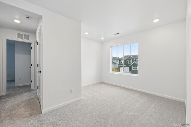 spare room with visible vents, carpet flooring, and baseboards