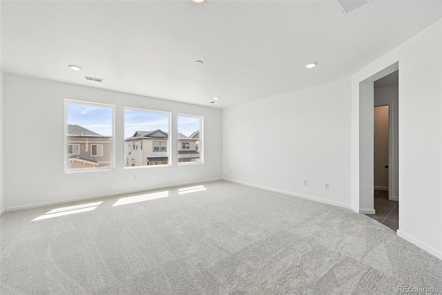 unfurnished room featuring visible vents, baseboards, carpet floors, and recessed lighting