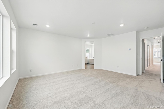spare room with light carpet, baseboards, and recessed lighting
