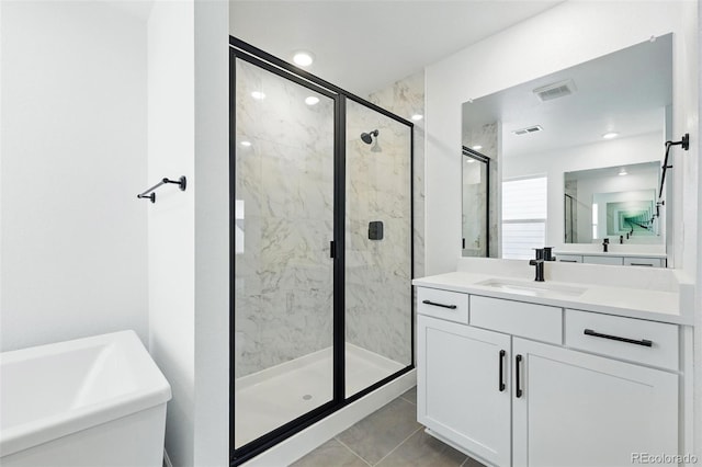bathroom featuring a freestanding bath, visible vents, vanity, and a marble finish shower