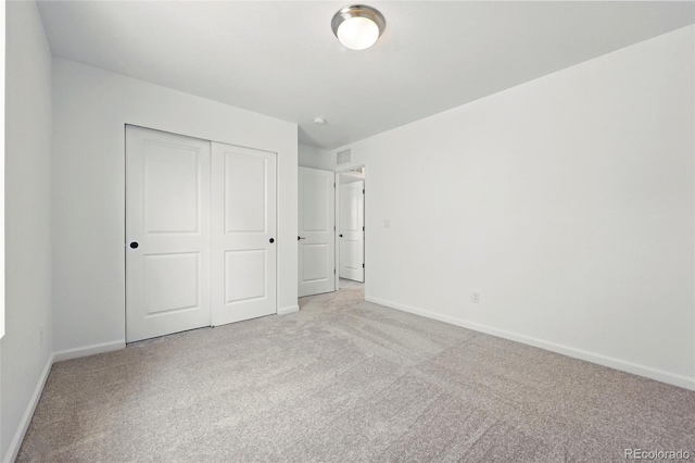 unfurnished bedroom with carpet, a closet, baseboards, and visible vents