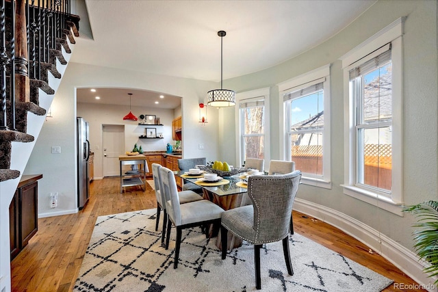 dining area featuring a wealth of natural light, light wood-style flooring, and baseboards