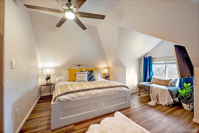 bedroom featuring hardwood / wood-style flooring, a ceiling fan, baseboards, and lofted ceiling