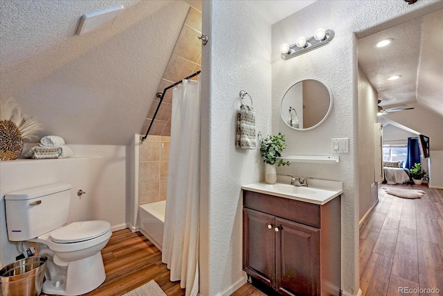 full bathroom featuring a textured ceiling, toilet, wood finished floors, and a textured wall