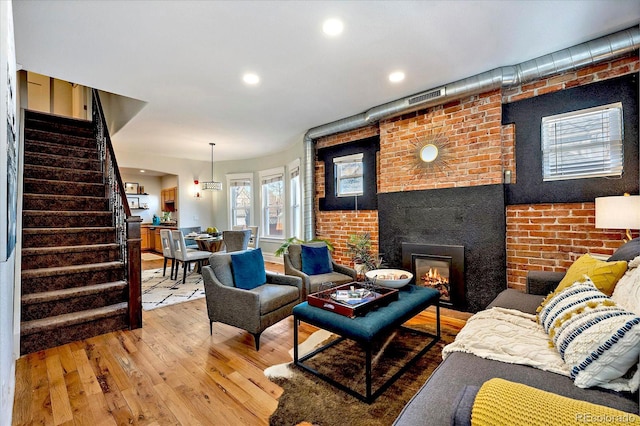 living room featuring visible vents, stairs, recessed lighting, a fireplace, and wood finished floors