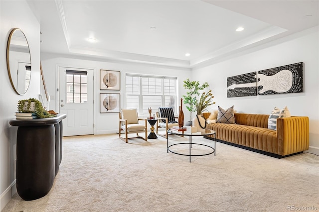 carpeted living area with a raised ceiling, plenty of natural light, recessed lighting, and baseboards