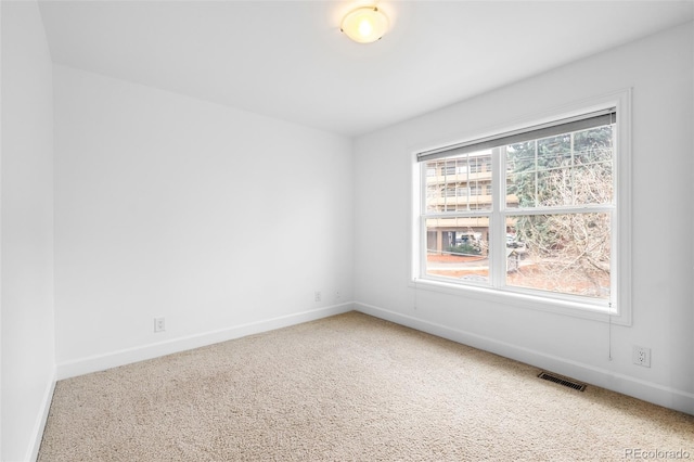 carpeted empty room featuring baseboards