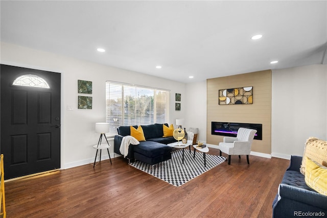 living room with a large fireplace and dark hardwood / wood-style flooring