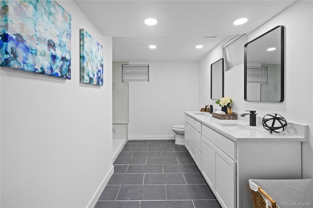 bathroom featuring toilet, dual vanity, and tile patterned floors