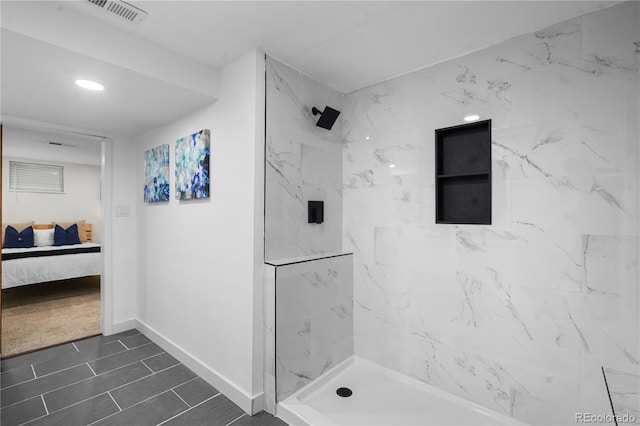 bathroom featuring tile patterned floors and a tile shower