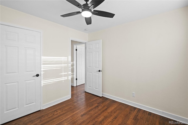 unfurnished bedroom with ceiling fan and dark wood-type flooring