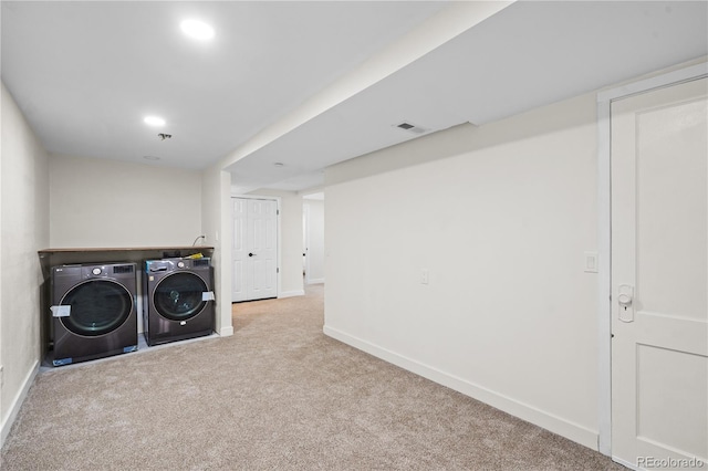 laundry area featuring washer and clothes dryer and light carpet