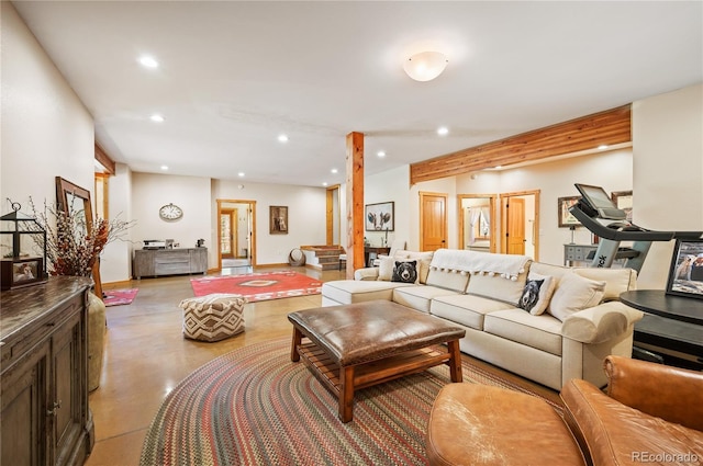 living room featuring recessed lighting, baseboards, and finished concrete floors