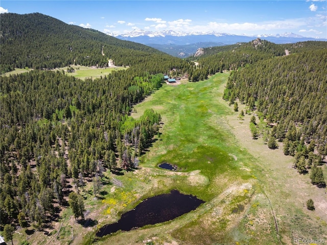 birds eye view of property featuring a mountain view and a wooded view