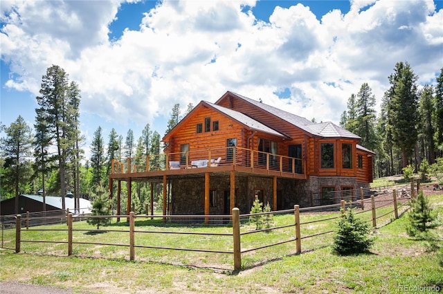 back of property featuring log siding, fence, and stone siding