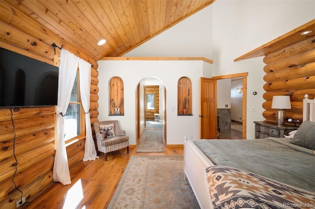 bedroom with baseboards, high vaulted ceiling, arched walkways, wood-type flooring, and wooden ceiling