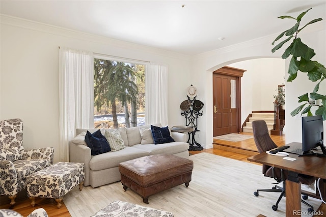 office space with arched walkways, light wood-type flooring, and crown molding