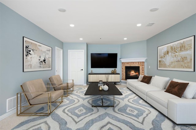 living room with recessed lighting, visible vents, a glass covered fireplace, and baseboards