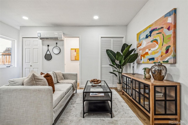 living room featuring an AC wall unit and hardwood / wood-style floors