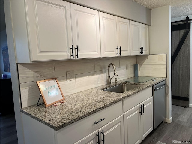 kitchen featuring white cabinetry, sink, stainless steel dishwasher, and stone countertops