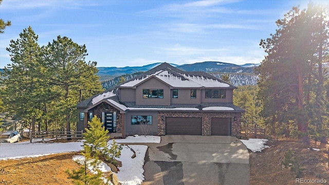 view of front of property with a garage, fence, a mountain view, and concrete driveway