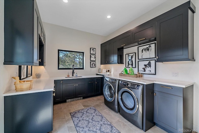 clothes washing area featuring cabinet space, washer and clothes dryer, a sink, and recessed lighting