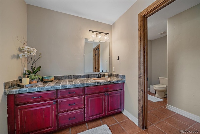 bathroom with baseboards, visible vents, toilet, tile patterned floors, and vanity