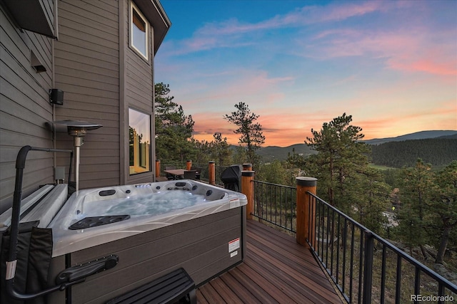 wooden deck with a hot tub and a mountain view