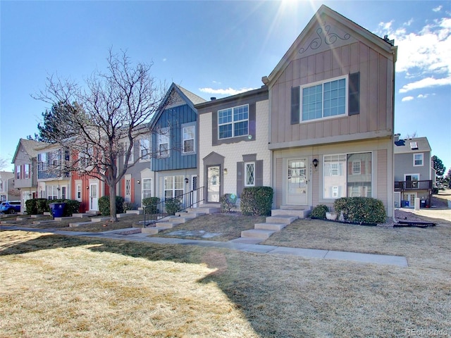 multi unit property featuring board and batten siding and a front lawn