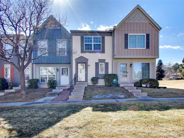 view of property with board and batten siding and a front lawn