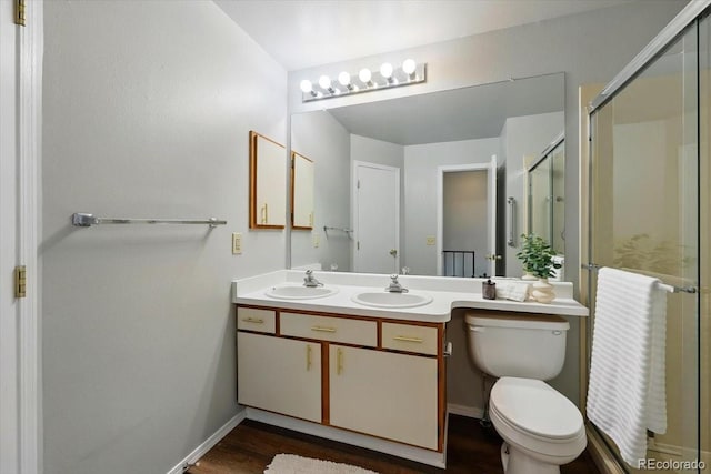 3525 Queen Anne Way, Colorado Springs, CO 80917 - bathroom featuring a shower stall, wood finished floors, double vanity, and toilet