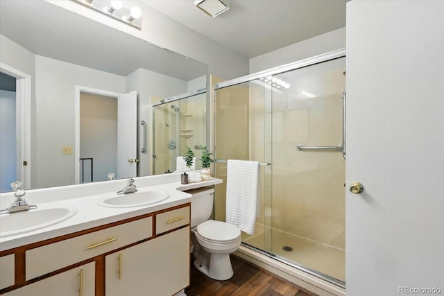 3525 Queen Anne Way, Colorado Springs, CO 80917 - full bath featuring a shower stall, wood finished floors, double vanity, and toilet