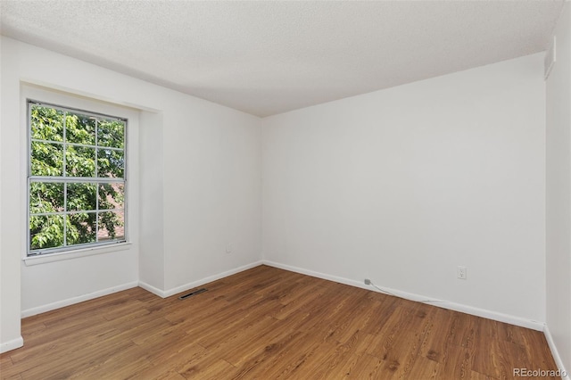 2013 S Helena St Unit B, Aurora, CO 80013 - unfurnished room with healthy amount of natural light, wood finished floors, and a textured ceiling