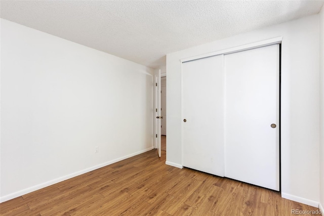 2013 S Helena St Unit B, Aurora, CO 80013 - unfurnished bedroom with light wood-type flooring, a closet, and a textured ceiling