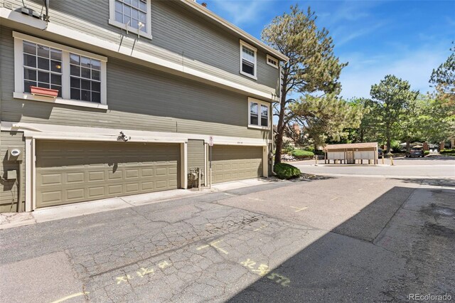 2013 S Helena St Unit B, Aurora, CO 80013 - view of property exterior with an attached garage and asphalt driveway