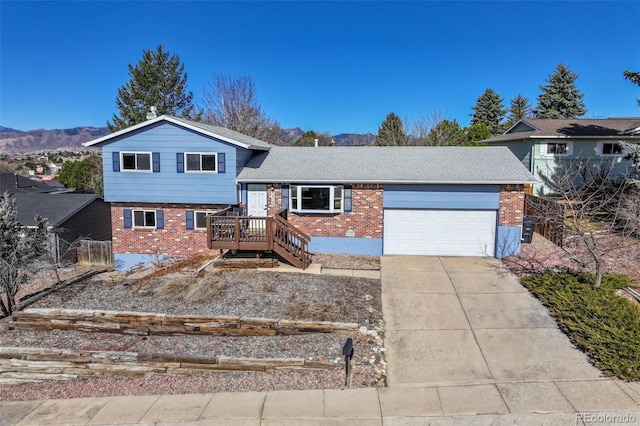 split level home with a garage, brick siding, and concrete driveway