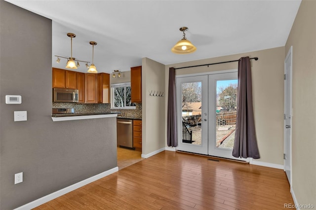 kitchen featuring stainless steel appliances, dark countertops, decorative backsplash, and french doors