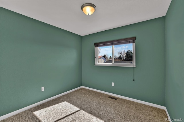 empty room with baseboards, visible vents, and carpet floors