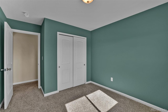 unfurnished bedroom with baseboards, a closet, and carpet floors