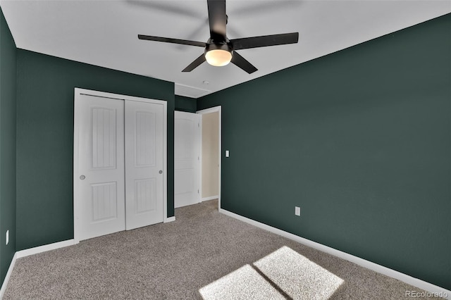 unfurnished bedroom with a closet, carpet floors, baseboards, and a ceiling fan