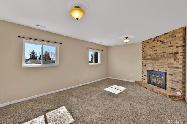 unfurnished living room with visible vents, a fireplace, carpet, and baseboards