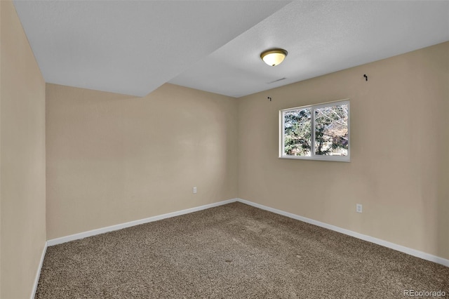 carpeted empty room featuring baseboards