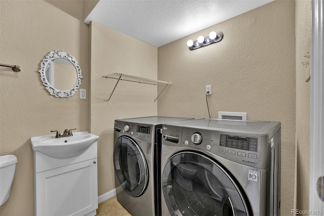 washroom with washer and dryer, laundry area, a textured wall, and a sink