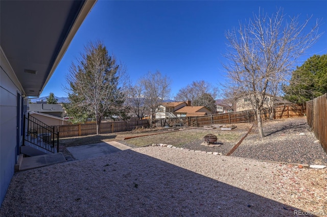 view of yard featuring a fire pit and a fenced backyard