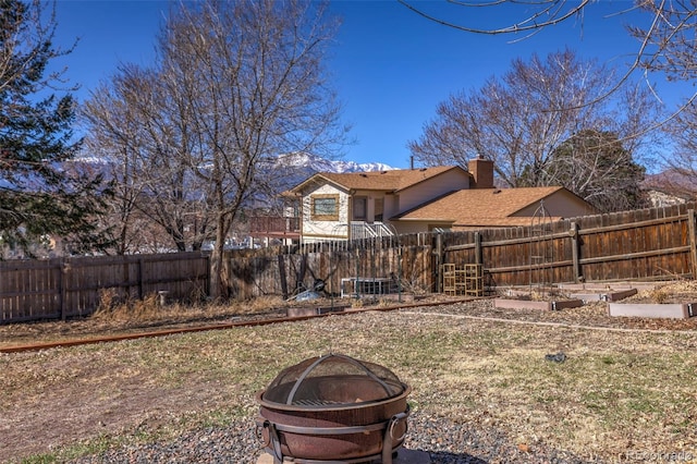 view of yard with a fire pit and a fenced backyard