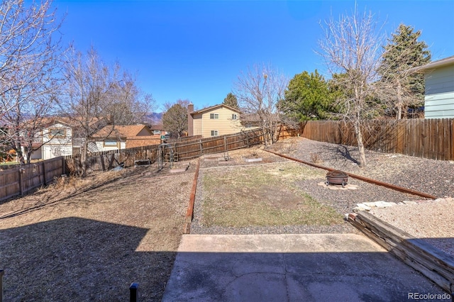 view of yard featuring a fire pit and a fenced backyard