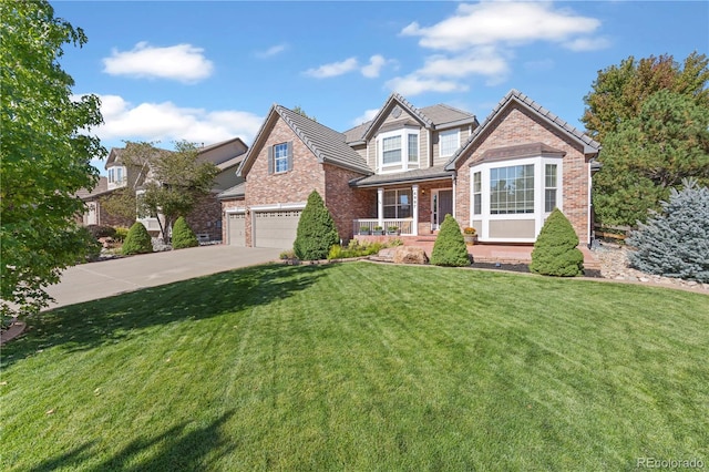 view of front of home featuring a front lawn, covered porch, and a garage